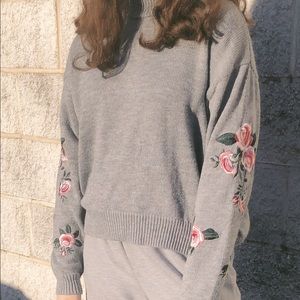 Grey sweater with embroidered roses on the sleeves
